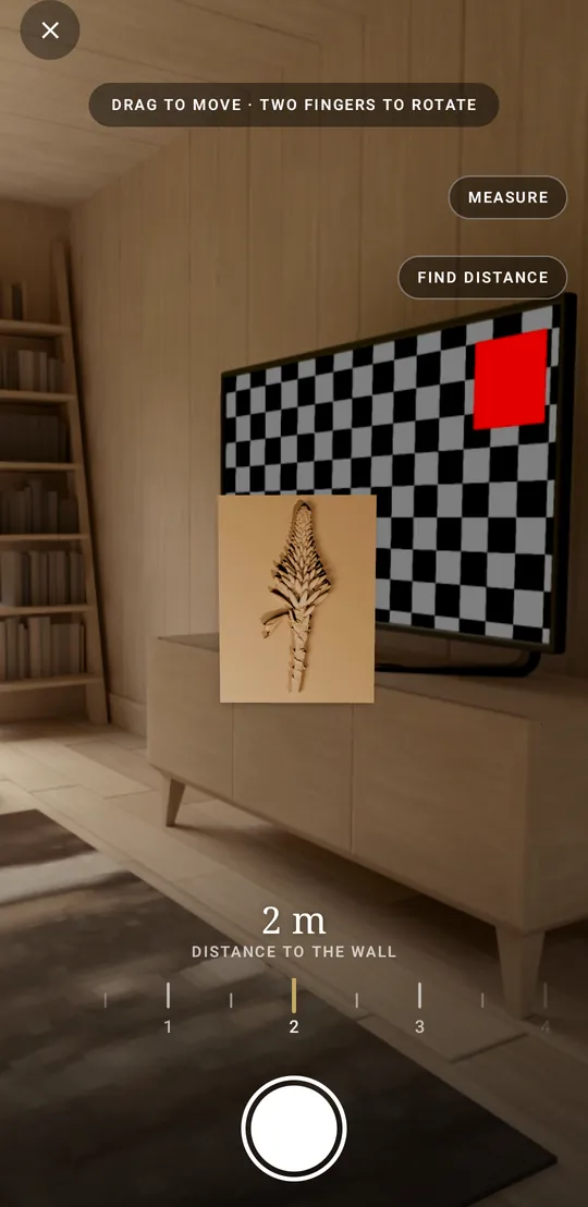 Glint's camera wall view: the Aloe Flower relief hung on a wall two metres away, with the distance dial and the shutter below